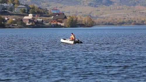 Man Boating Across a Tranquil Lake in Summer