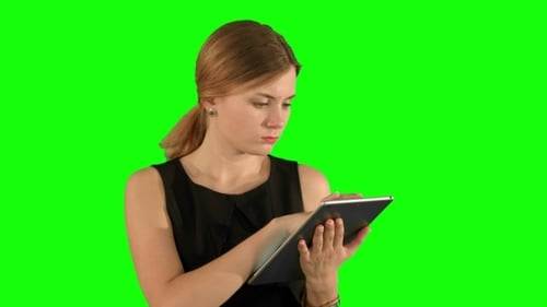 Young Woman Using a Tablet On a Green Screen