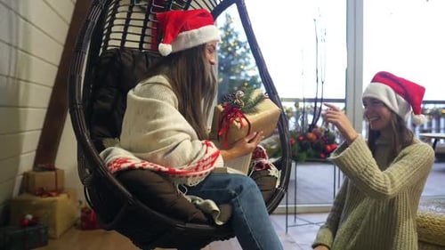 Two Women Exchanging Christmas Gifts in a Home