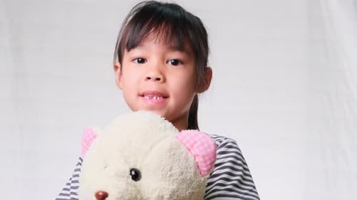 Child Holding Stuffed Bear Looking at Camera
