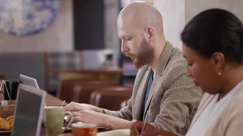 Diverse Colleagues Working during Lunch in Cafe