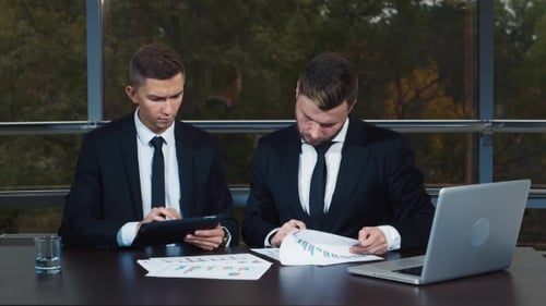 Successful Businessmen Reviewing Data in Bright Modern Office