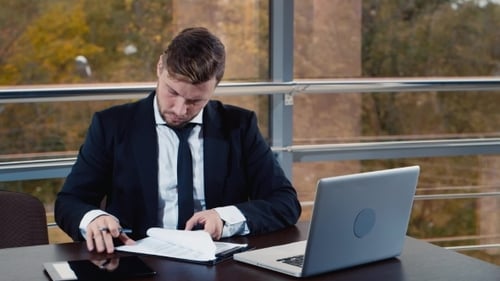 Successful Businessman Working At Desk With Laptop