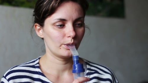 Femme porte un masque pour inhalation, et conduit