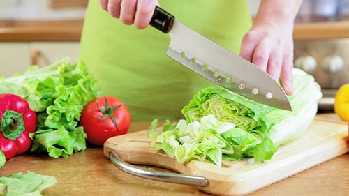 Person Chopping Fresh Vegetables in a Kitchen