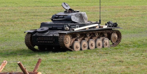 Tank Driving Across Green Grassy Field