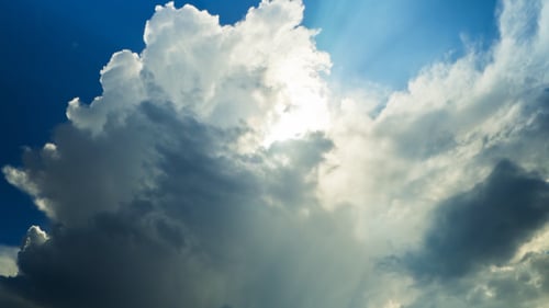 Dramatic White Clouds Drifting Across Blue Sky