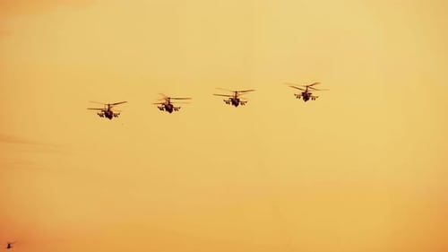 Military Helicopters Flying in Formation at Sunrise