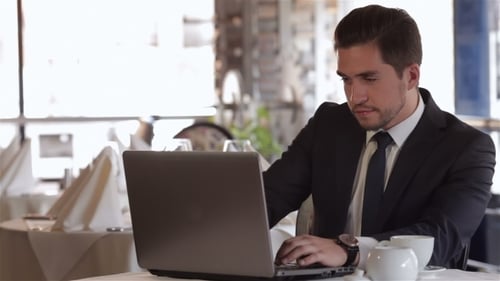 Man Using Laptop At Lunchtime At a Cafe