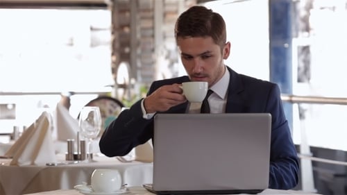 Man Working on Laptop in Restaurant
