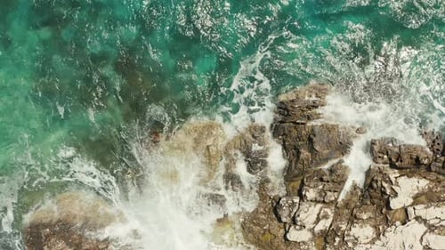 Aerial View Blue Ocean Waves Crashing Against a Rocky Shore