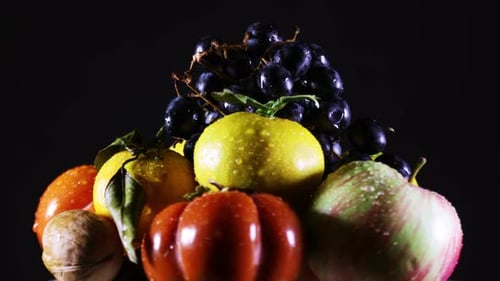 Frische, feuchte Früchte rotieren über Schwarz