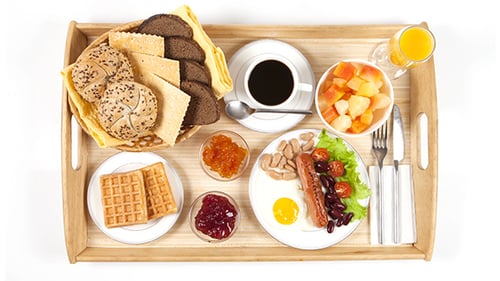 Breakfast Foods Being Arranged on Wooden Tray