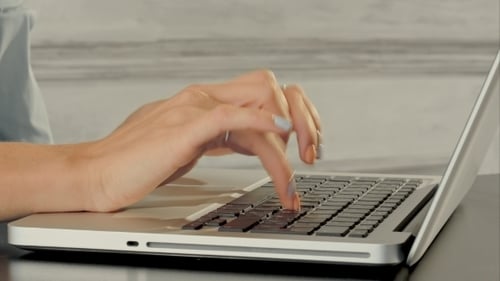 Adult Hands Typing on Laptop Keyboard
