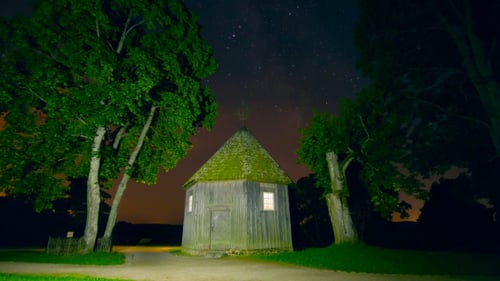 Quaint Chapel Lit Under Starry Night Sky