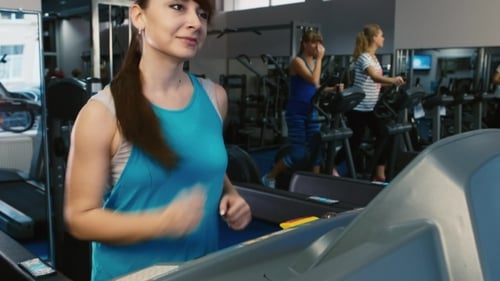 Attractive Woman Running On a Treadmill, Smiling