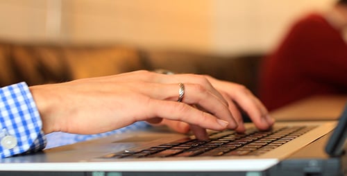 Person Typing on Laptop Keyboard, Close-Up View