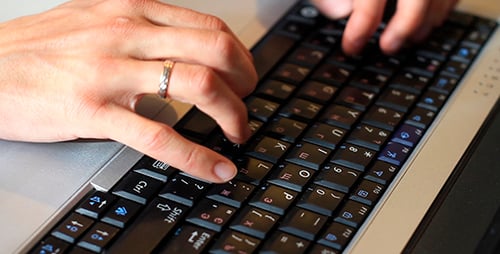 Hands Typing on Laptop Keyboard in Close Up