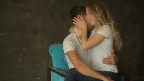 Laughing Couple Embracing While Covered in Feathers