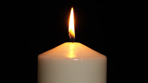 Single Candle Flame Burning Brightly in the Dark