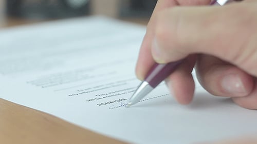 Homme signant un contrat d'affaires au bureau