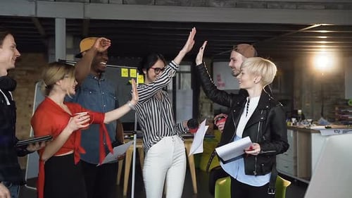 Team Celebrates with a High Five in Office