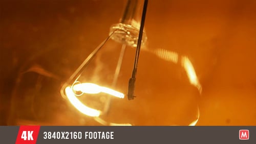 Orange Lightbulb Glowing Brightly on Black