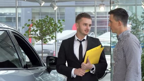 Car Salesman Talking to a Man in Dealership