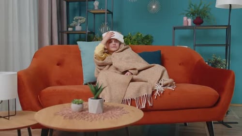 Child with Cold Compress Resting on Sofa