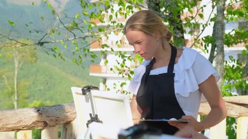 Young Woman Painting Outdoors on Sunny Day