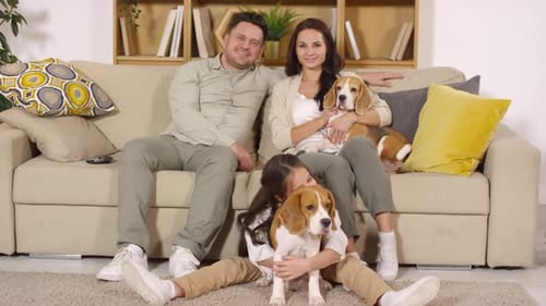 Family Smiles with Their Dogs Indoors