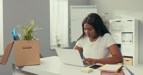 Ambitious Company Employee Sits in Office in Front of Computer Girl Works on Laptop Looks Into Bank