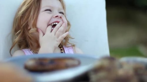 Happy Girl Enjoys Outdoor Barbecue with Family