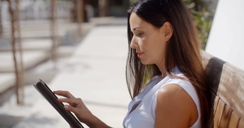 Woman Using Tablet Outdoors on Sunny Day