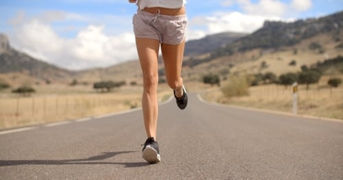 Fit Girl Running On Mountain Road