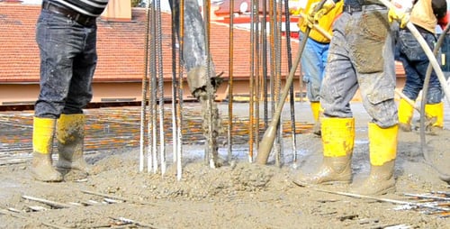 Bauarbeiter beim Gießen einer Betonplatte