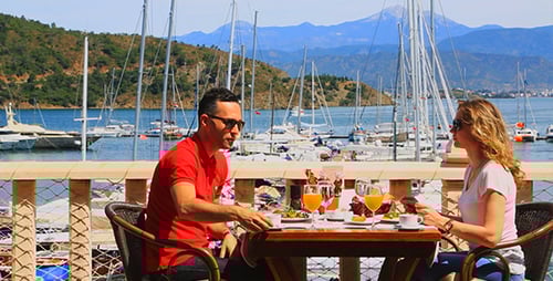 Couple Dining at Seaside Restaurant Overlooking Harbor