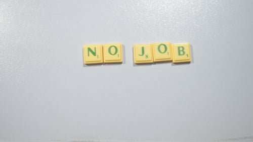 Hands Spell Out "No Job" With Scrabble Letters
