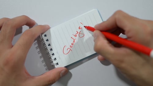 Writing Goodbye Message in Red Marker on Notebook