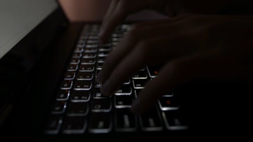 Dedos en el teclado en la oscuridad