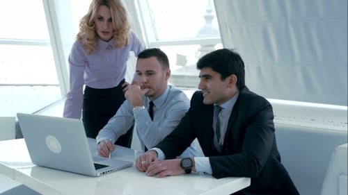 Business Team Collaborating on a Laptop in Office