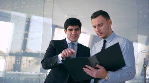 Businessmen Reviewing Documents in Modern Office Setting