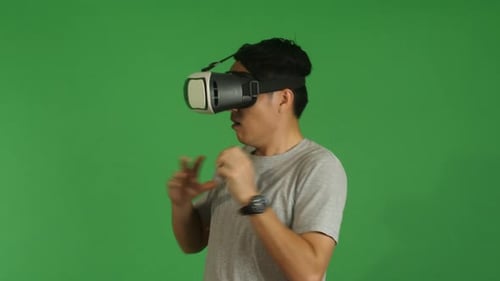 Man Experiences Virtual Reality Headset on Green Screen