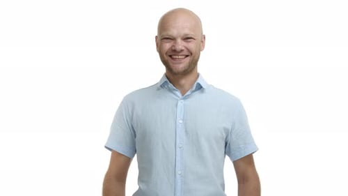 Bald Man Smiles in a Light Blue Shirt