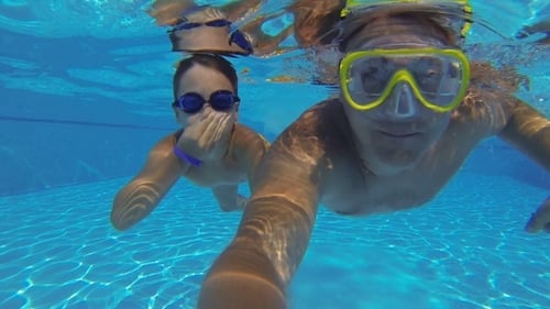 Boy And Father Diving In Swimming Pool