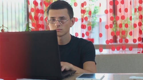 Man Using Laptop in a Cafe