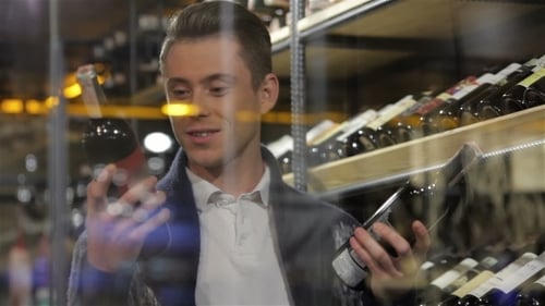Man In a Comparing Two Wines Bottles