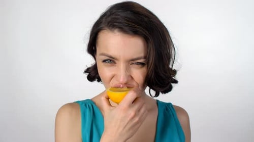 Cheerful Woman Eating Orange and Winking