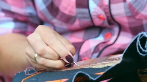 Woman Embroidering Black Fabric in Embroidery Hoop