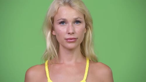 Young Beautiful Woman with Blond Hair Against Green Background